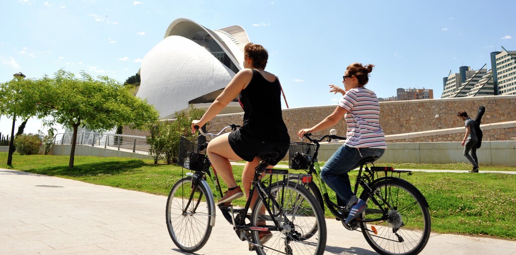 Turistas paseando con sus bicis de alquiler de Doyoubike junto al Palau de les Arts