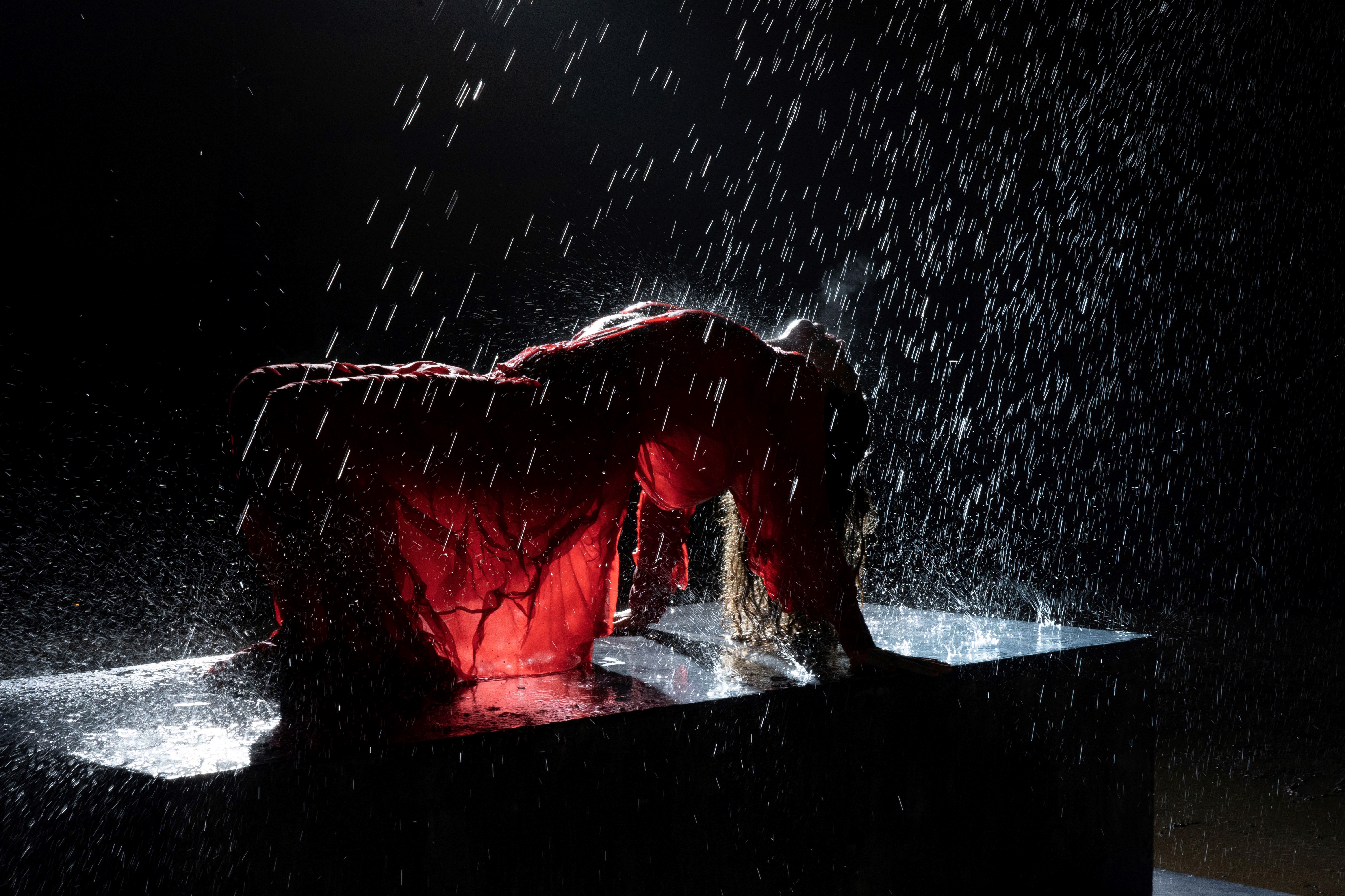 Imagen de una mujer boca arriba rociada con agua en un espectáculo