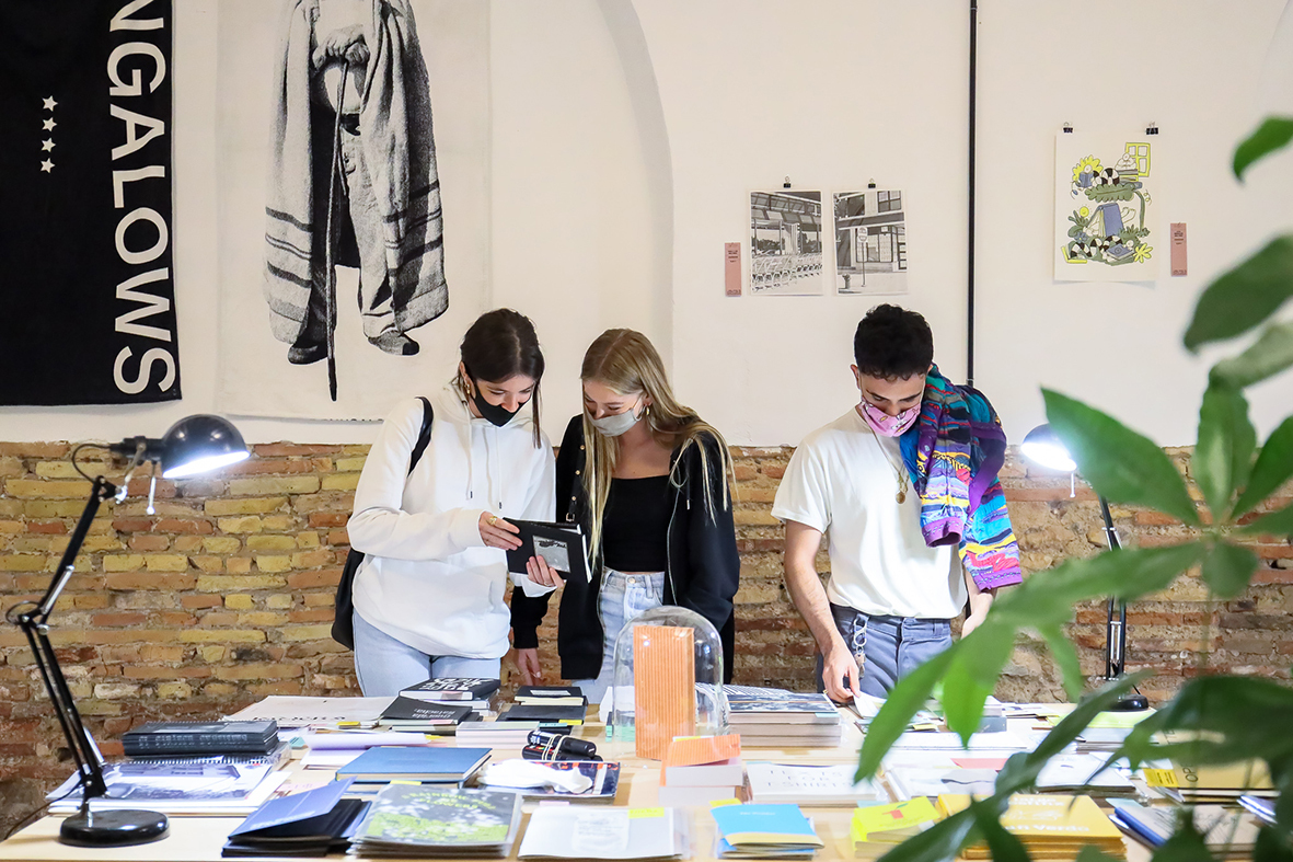 Tres jóvenes mirando libros en la Feria RECREO