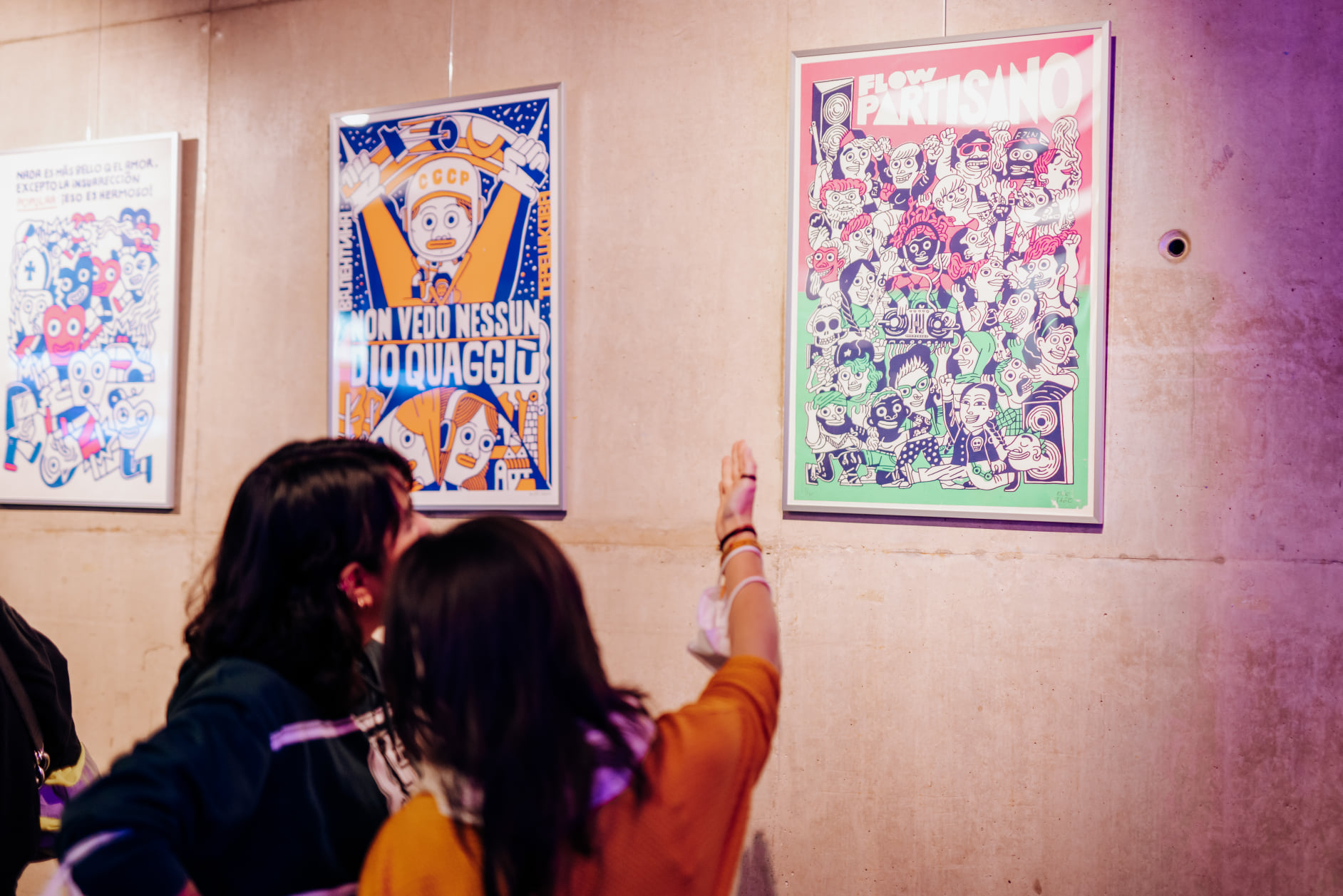Dos mujeres observan un poster colorido en la exposicion