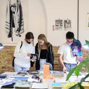 Tres jóvenes mirando libros en la Feria RECREO
