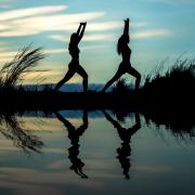 dos deportistas practicando yoga al aire libre